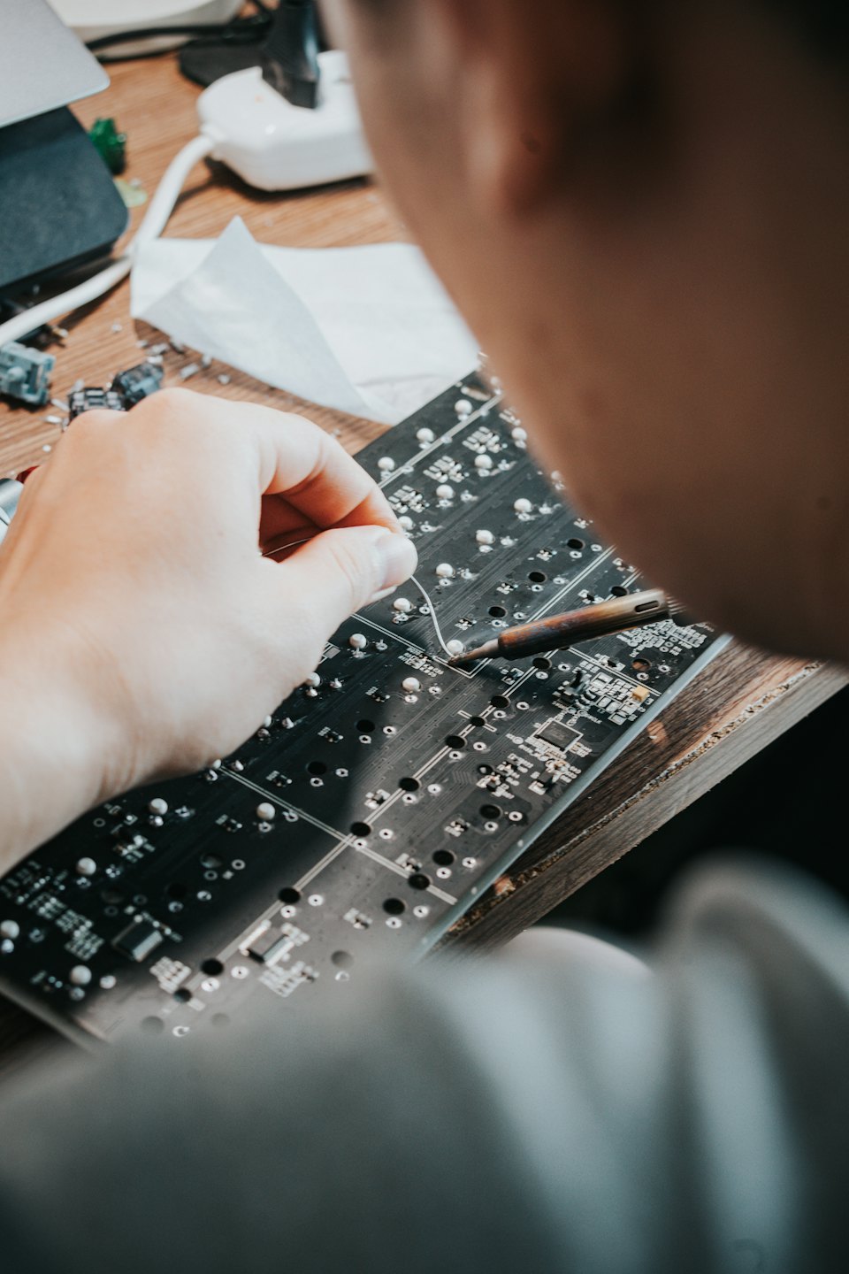 Person soldering electronic components onto a circuit board.
